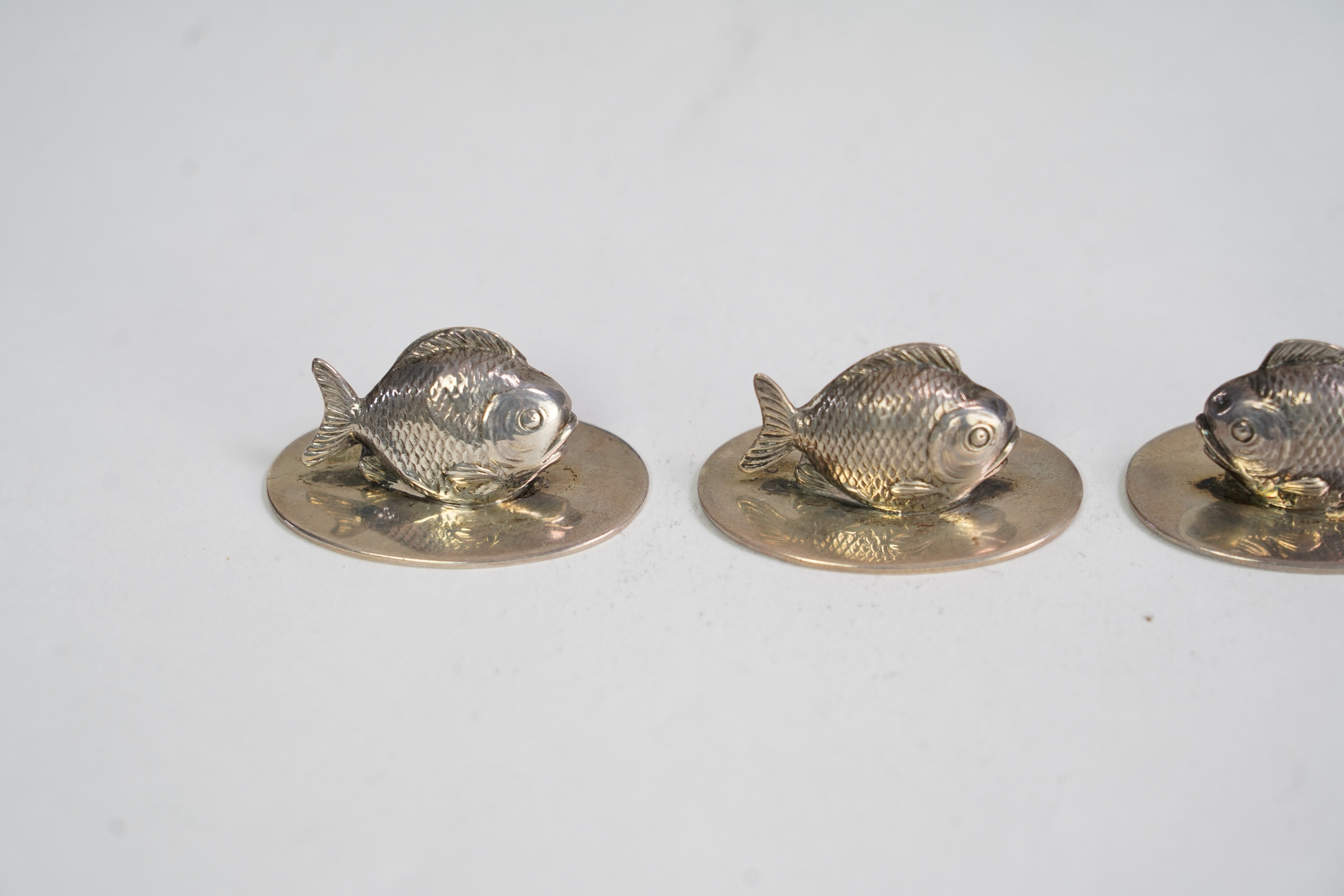 A cased set of two pairs of Edwardian silver menu holders, each modelled as a fish, by Sampson Mordan & Co